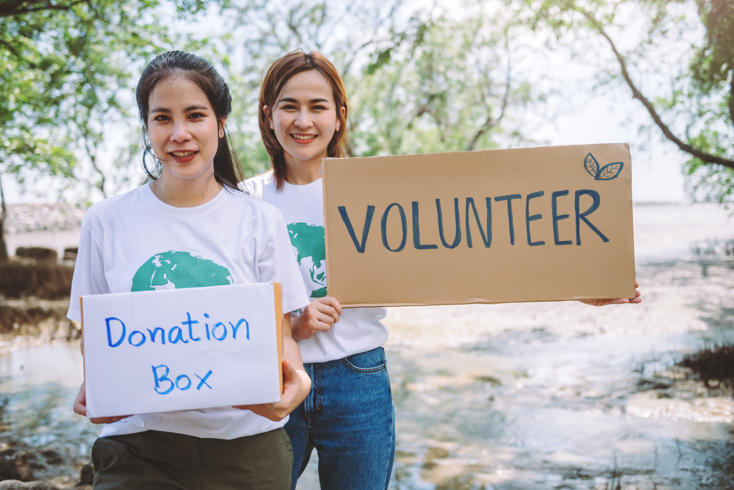 Group of volunteers hold a volunteer sign in world environment day event, volunteer conservation pick up plastic and foam garbage on mangrove forest area.Volunteering save world concept.